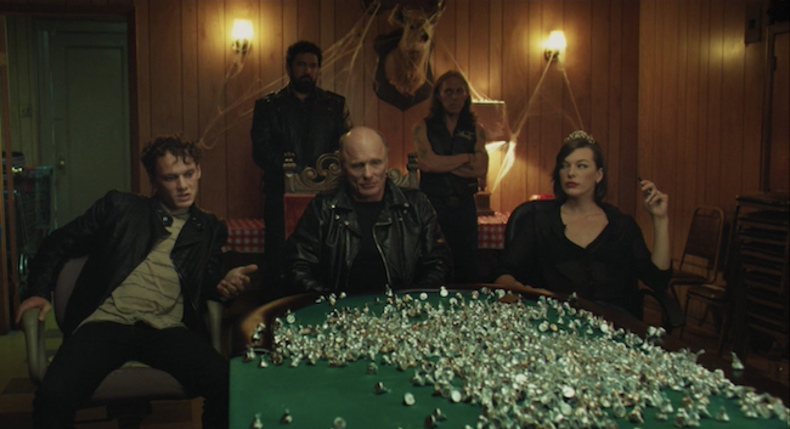 Cymbeline's court rejecting the tribute. Ed Harris as Cymbeline, Milla Jovovich as the Queen, and Anton Yelchin as Cloten