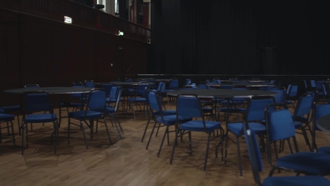 Thumbnail for entry Empty stage hall pan with empty seats and tables