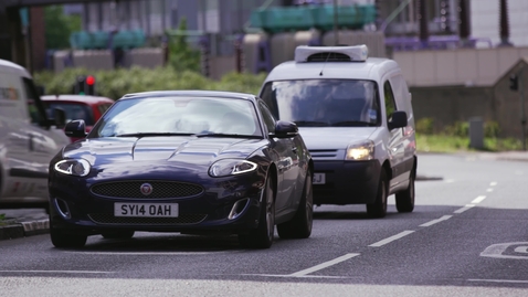 Thumbnail for Luxury car driving through busy urban street
